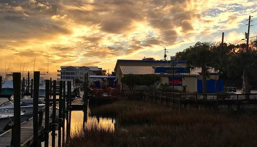 View of Fish House Grill exterior from the dock during sunset.